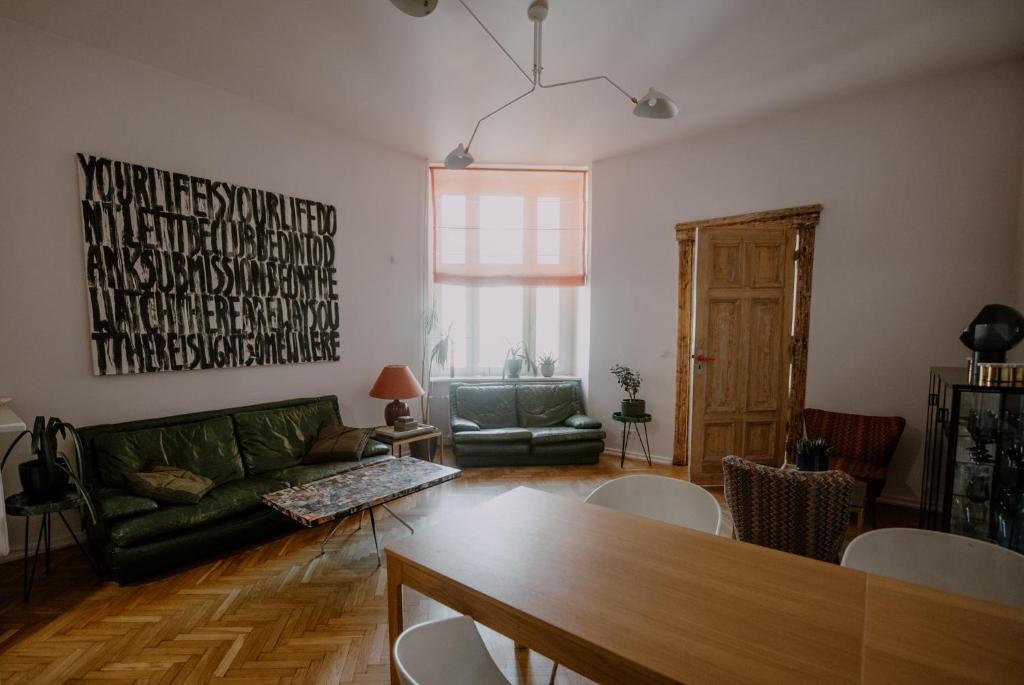 ein Wohnzimmer mit einem grünen Sofa und einem Tisch in der Unterkunft Space Age Residence in Łódź