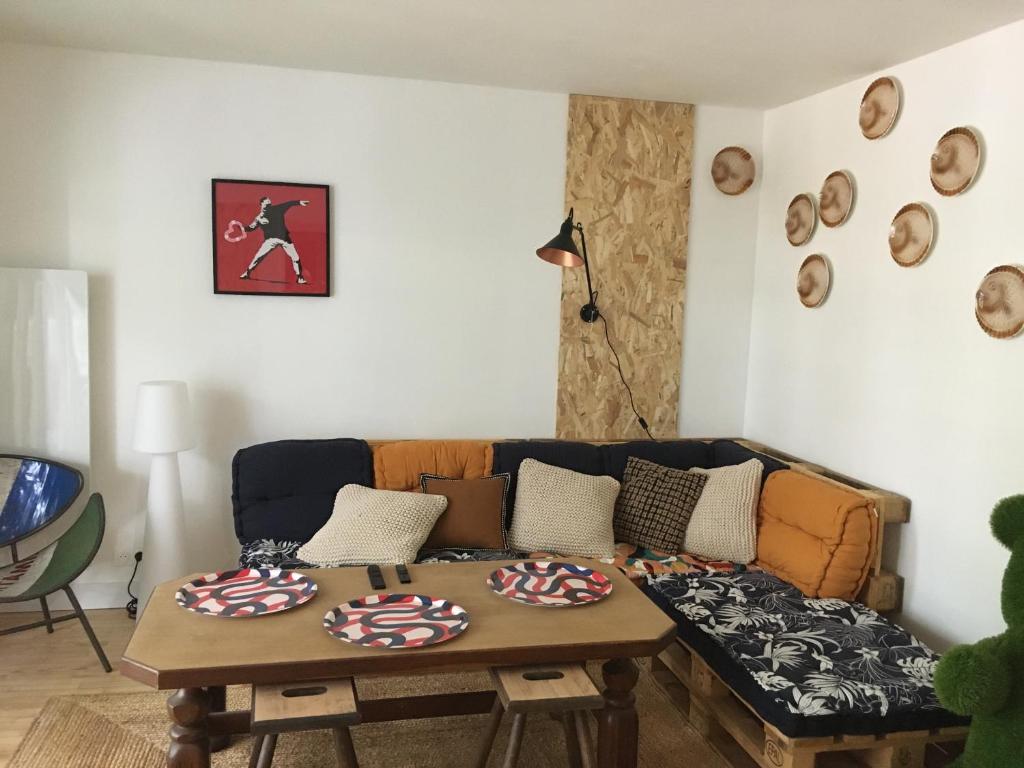 un salon avec un canapé et une table dans l'établissement Banane & C avec sa terrasse, à Lorient