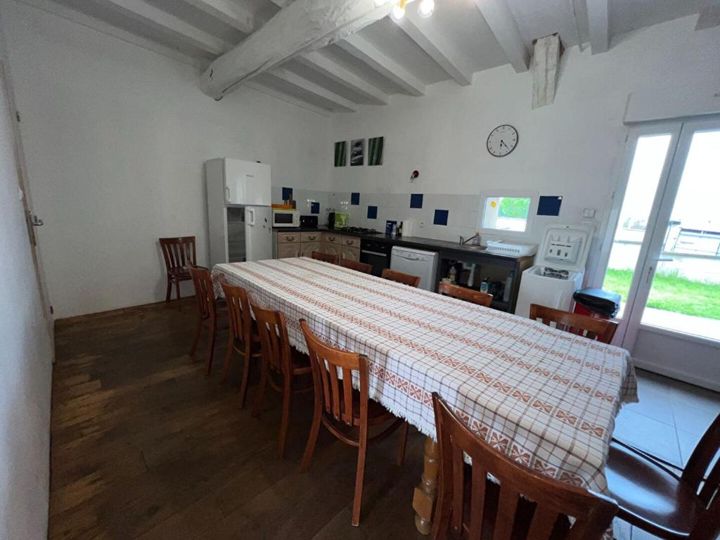 - une cuisine et une salle à manger avec une table et des chaises dans l'établissement Maison avec terrasse - 12 personnes, à Saint-Yan