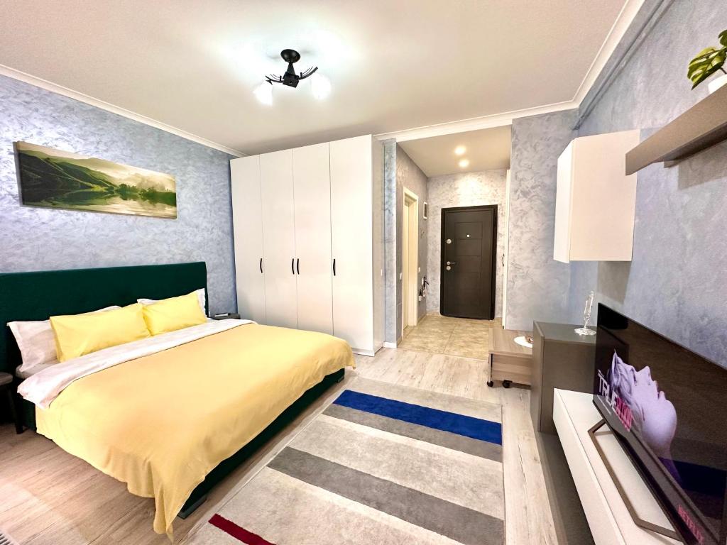 a bedroom with a large bed and a tv at Nice apartment in Militari Residence in Roşu