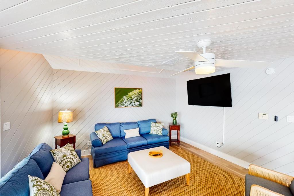 a living room with a blue couch and a tv at The Roller Coaster River Retreat in Tampa