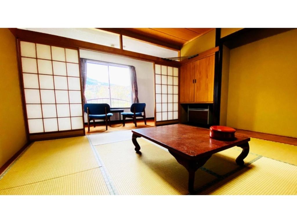um quarto com uma mesa e cadeiras num quarto em Hotel & Onsen 2307 Shigakogen - Vacation STAY 72767v em Shiga Kogen