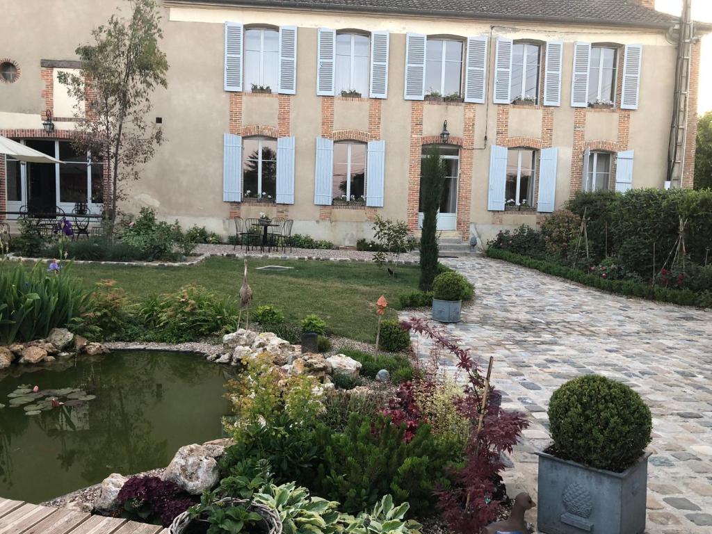 une maison avec un étang en face d'un jardin dans l'établissement La Demeure d'Agapanthe, à Vinay