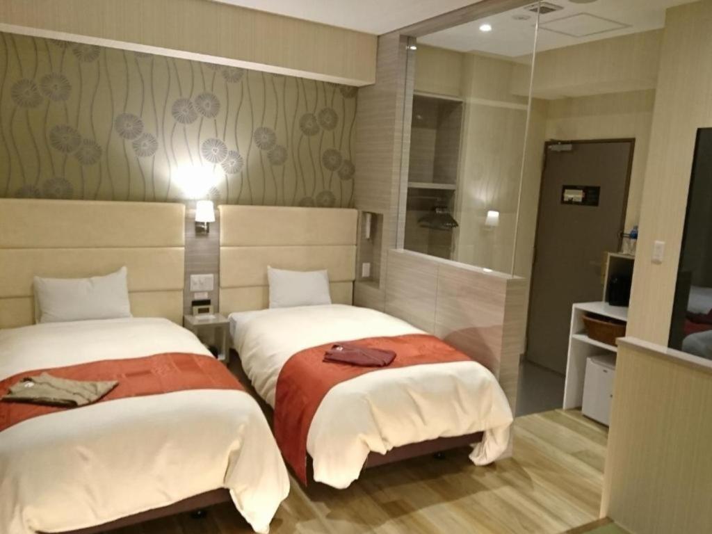 a hotel room with two beds and a mirror at QUEEN'S HOTEL CHITOSE - Vacation STAY 67739v in Chitose