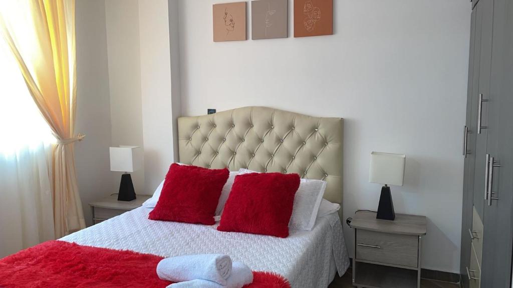 1 dormitorio con 1 cama grande con almohadas rojas en Moderno apto familiar piso 2 en Santa Rosa de Cabal