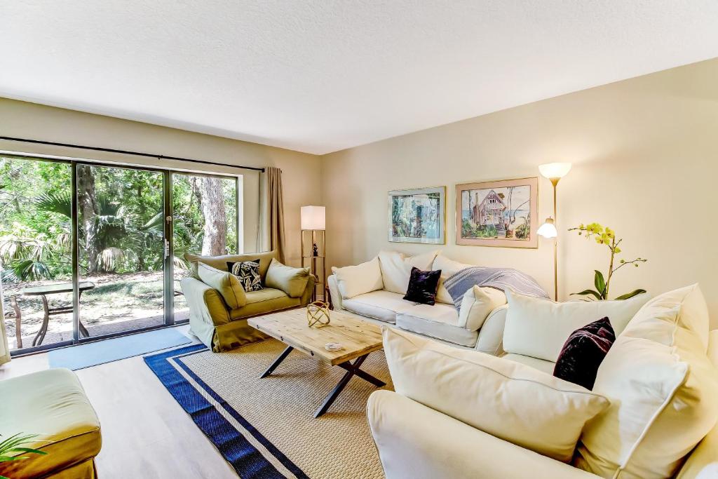 a living room with white furniture and a large window at 2060 Beach Wood in Amelia Island