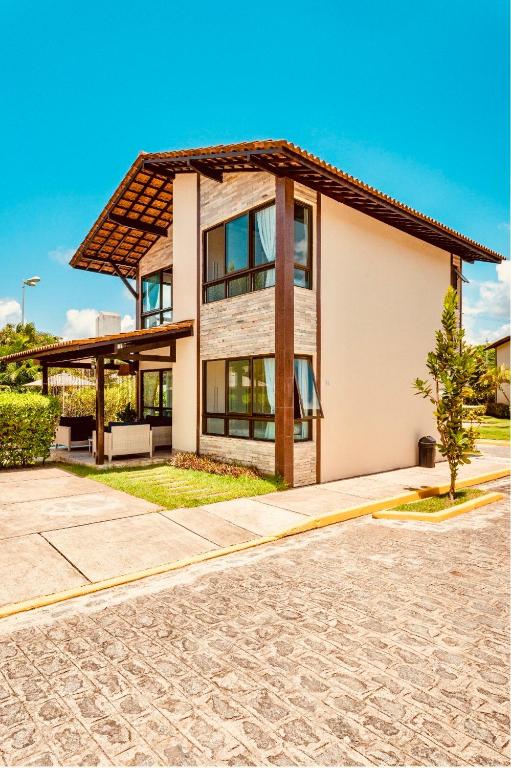 a house with a gambrel roof at Bangalô Boutique com piscina Privativa - 3 Suítes in Porto De Galinhas