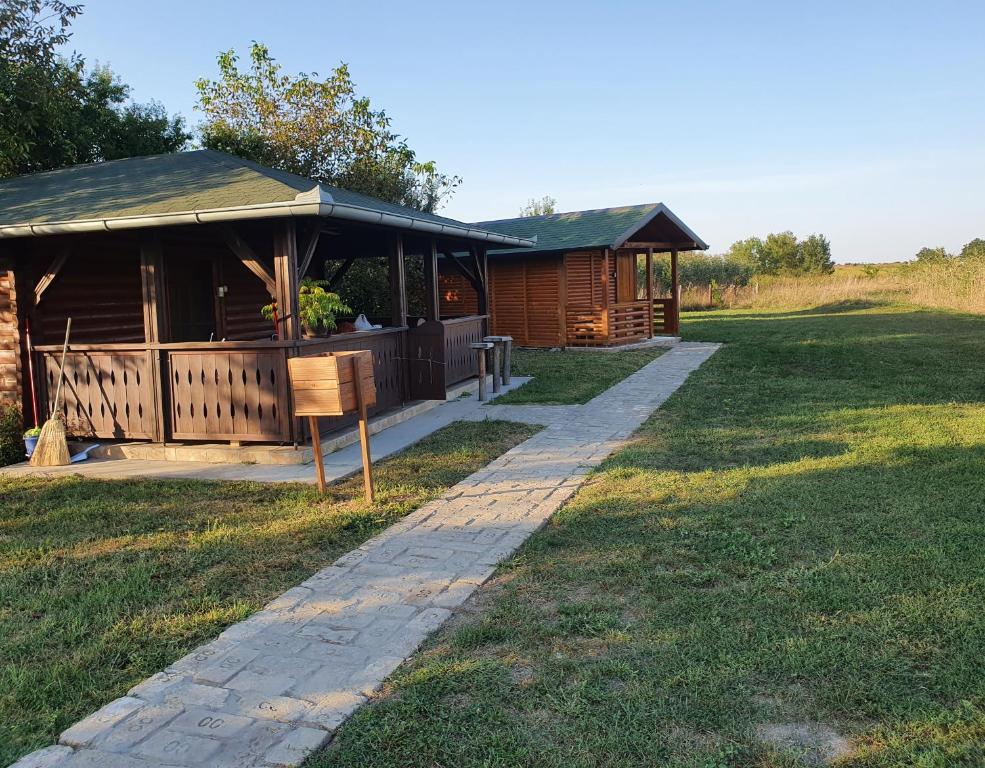 una cabaña en un campo con un camino delante en Brvnara Lenka en Temerin