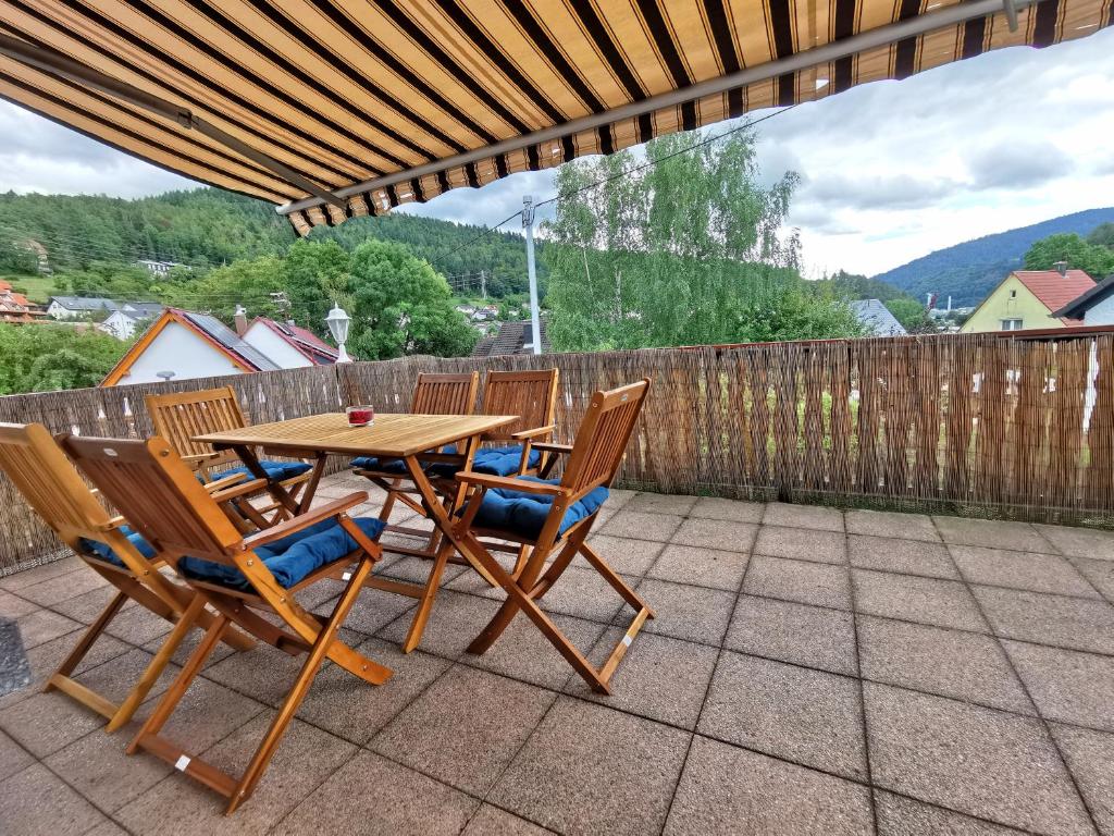 a wooden table and chairs on a patio at 3 Zimmer-Apartment mit Terrasse in Gernsbach