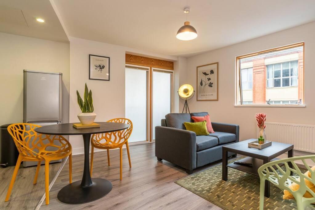 een woonkamer met een bank en een tafel bij Stunning Brand New One Bed City Apartment in Leicester