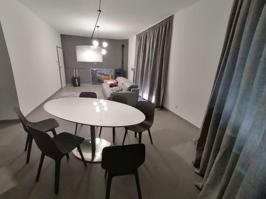 un salon avec une table et des chaises blanches dans l'établissement Apartamento minimalista Centenário, à São Brás de Alportel