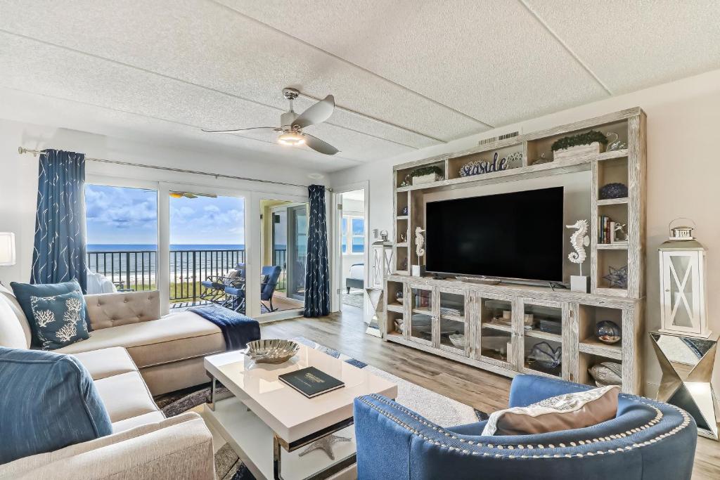 a living room with a couch and a tv at Amelia South C3 in Amelia Island