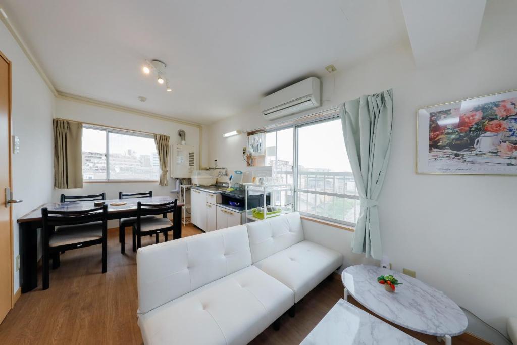 een woonkamer met een witte bank en een tafel bij Grace Heiwajima - Vacation STAY 15464 in Tokyo