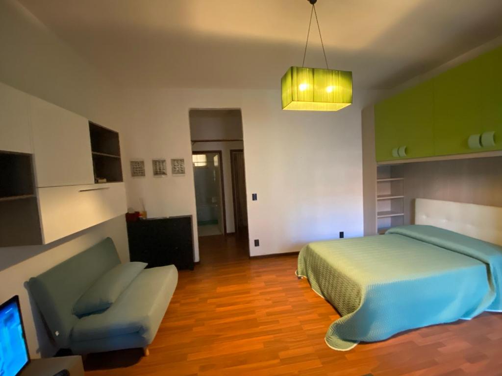 ein Schlafzimmer mit einem Bett, einem Sofa und einem TV in der Unterkunft Gabe in Cesena