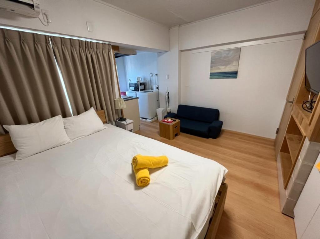 Un dormitorio con una cama con una toalla amarilla. en Rhodes Kagurazaka - Vacation STAY 77347v, en Tokio