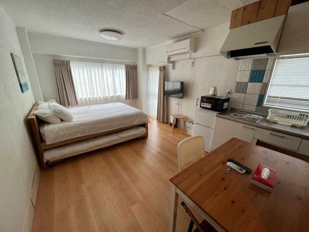 1 dormitorio con 1 cama y cocina con mesa en Rhodes Kagurazaka - Vacation STAY 77350v en Tokio