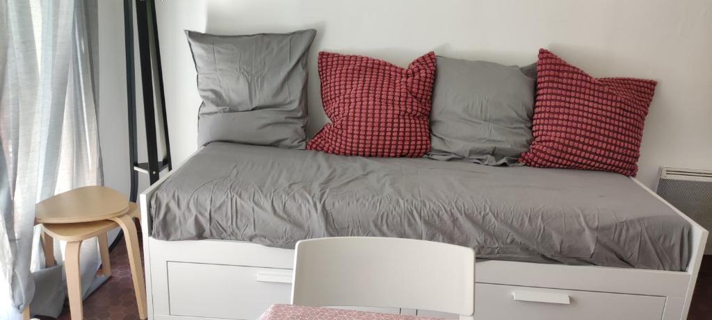 a bed with pillows on it in a room at appartement T1bis St Lary soulan village in Saint-Lary-Soulan