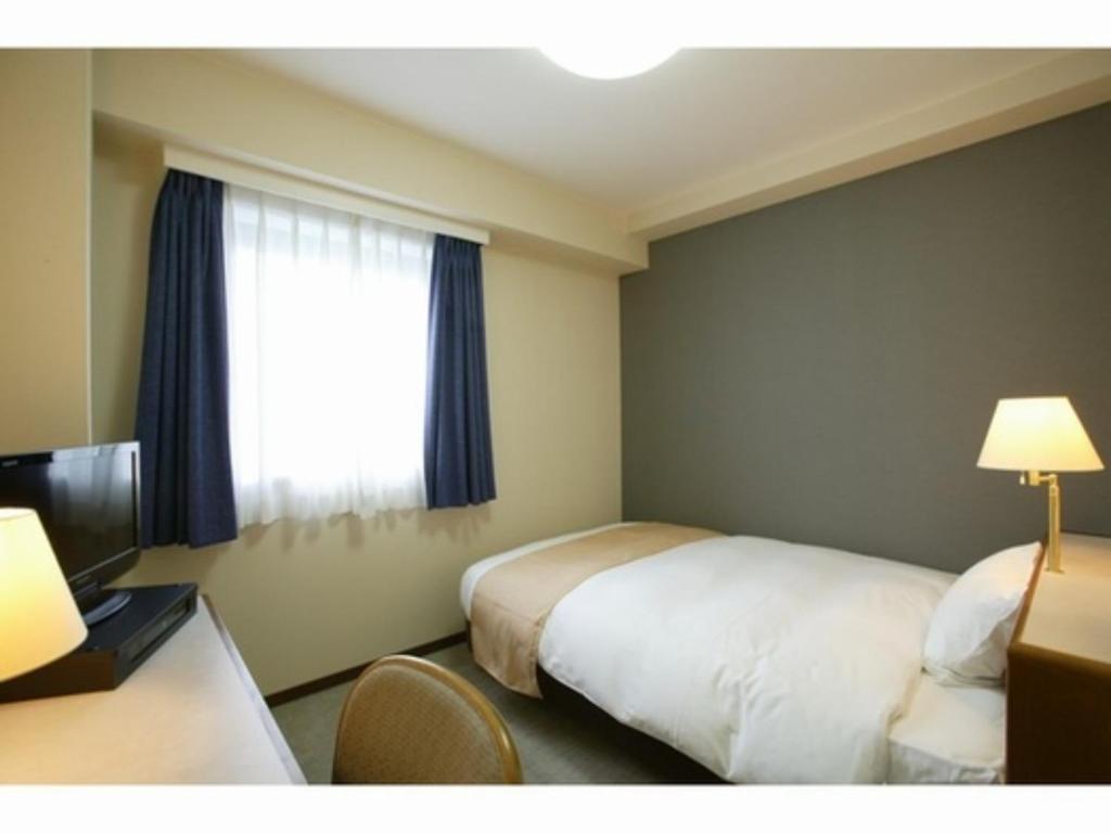 a hotel room with a bed and a window at Hotel Montagne Matsumoto - Vacation STAY 73668v in Matsumoto