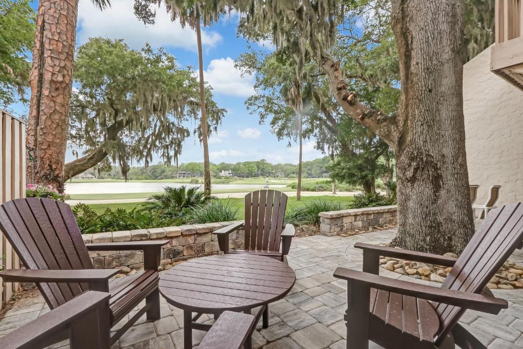 a wooden table and chairs sitting on a patio with trees at 2091 Beach Wood in Amelia Island