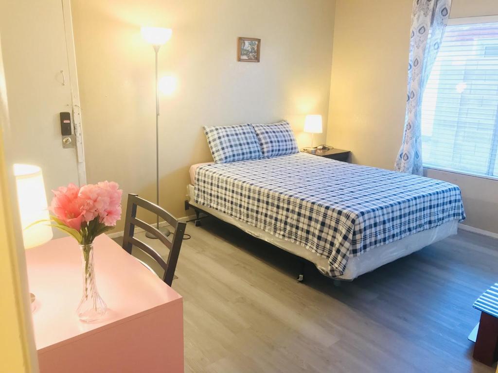 a bedroom with a bed and a table with a vase of flowers at Independent bedroom with private bathroom#2 in Las Vegas