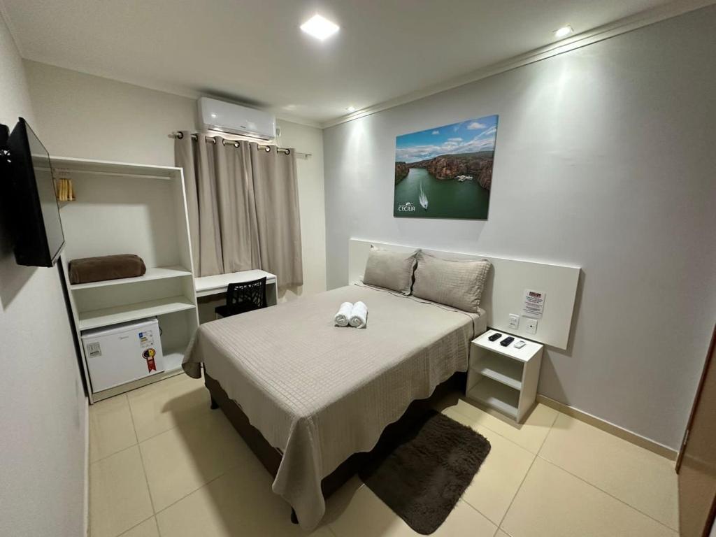 a small bedroom with a bed and a tv at POUSADA CECILIA in Canindé de São Francisco