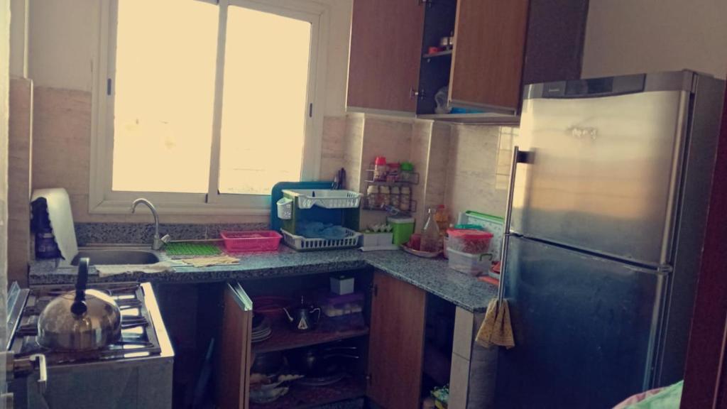una cucina con frigorifero in acciaio inossidabile e lavandino di STUDIO OUSSAMA a Bouskoura