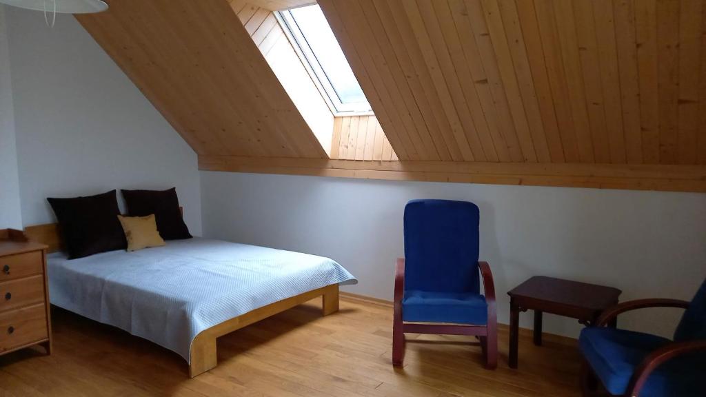 um quarto com uma cama, uma cadeira e uma janela em U Janciów em Cracóvia