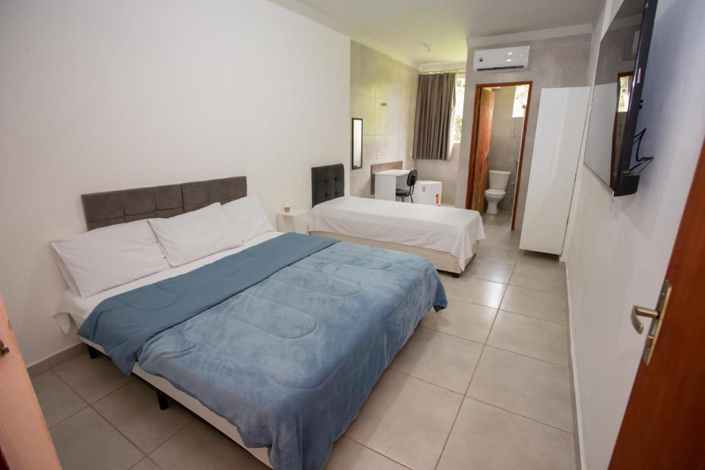 a hotel room with two beds and a television at Ribeiro Suit's Hotel in Araxá