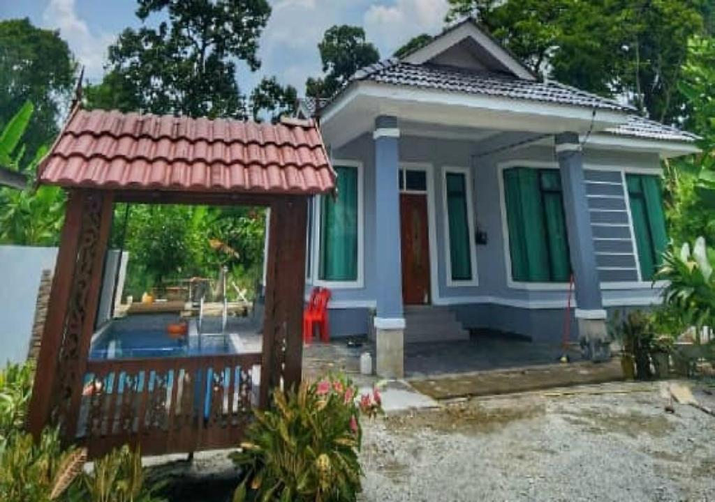une petite maison avec une porte en face dans l'établissement Homestay Durian Belanda, à Jertih