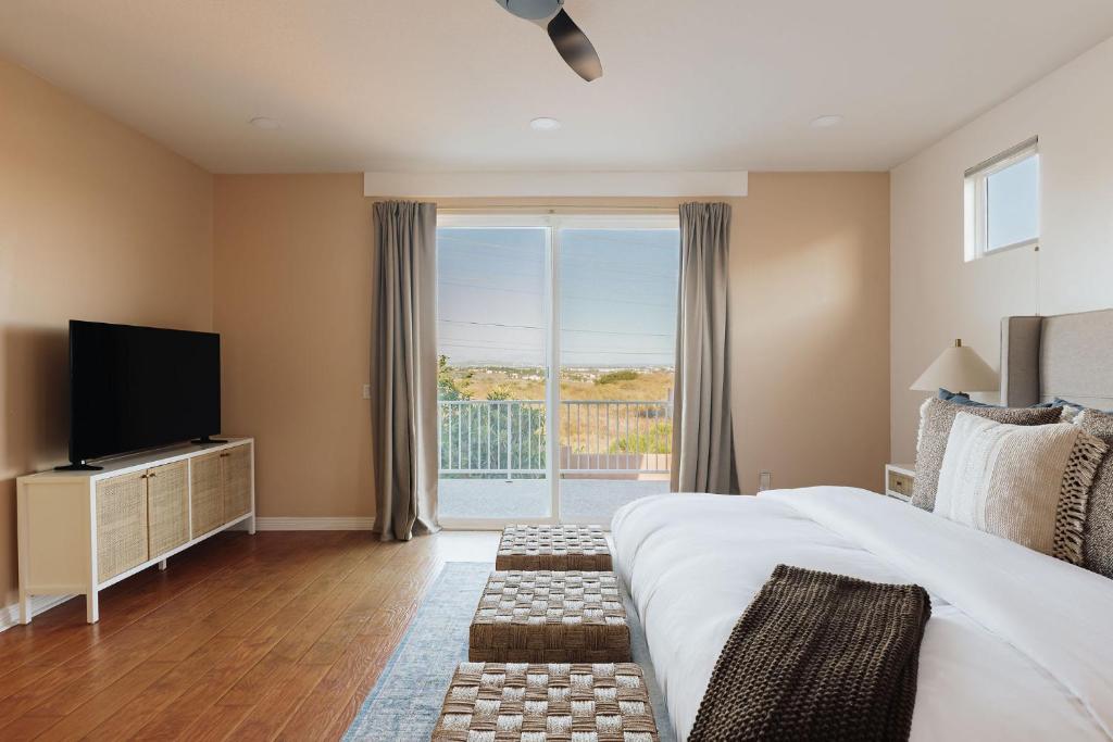 una camera con un grande letto e una televisione di Luxe Boho Retreat Near Torrey Pines - Sleeps 10 a San Diego