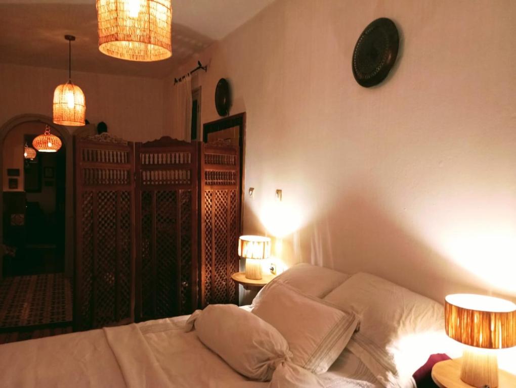 - une chambre avec un lit avec deux lampes et deux tables dans l'établissement Dar SBAA, à Chefchaouen