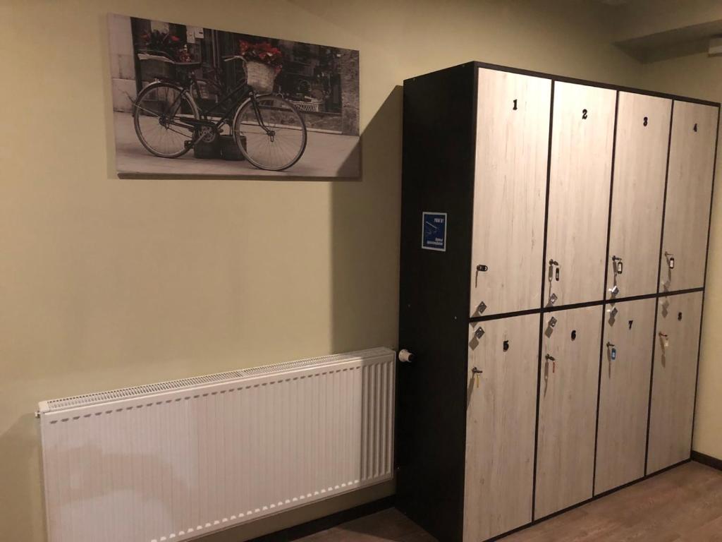 Cette chambre comprend des casiers et un vélo sur le mur. dans l'établissement Apart Hotel Avinos, à Lviv