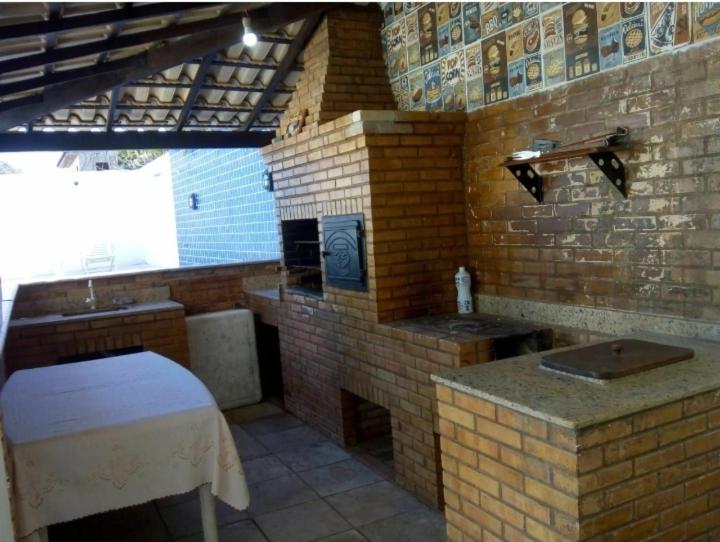cocina con pared de ladrillo y fogones en Casa Buzios moreira campos, en Búzios