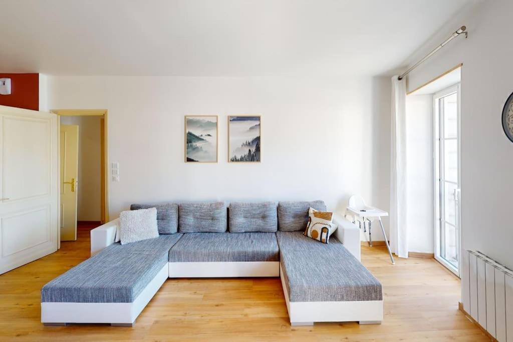 a large couch in a room with white walls at Appartement Lafayette N°3 in Bagnères-de-Bigorre