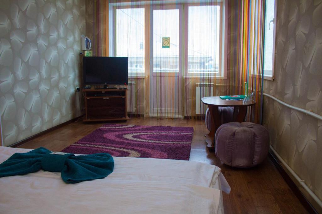 um quarto de hotel com uma cama e uma televisão em Сити em Petropavl