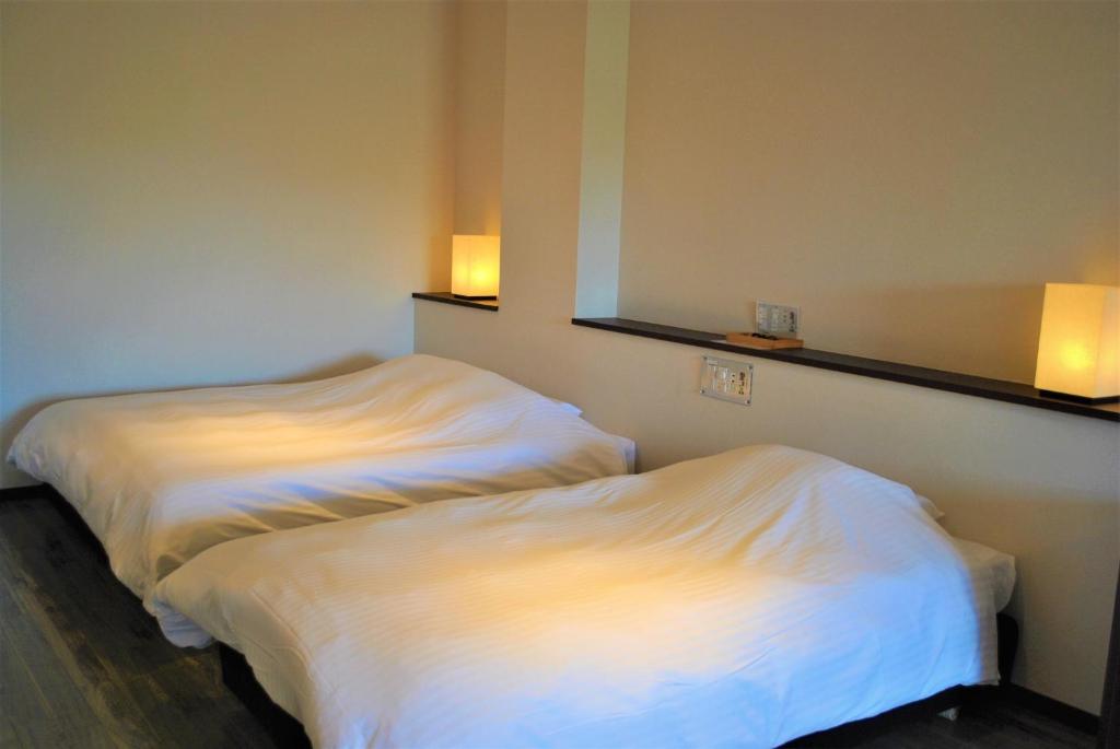 一関市にあるKajitsu no mori - Vacation STAY 53766vのベッド2台が隣同士に設置された部屋です。