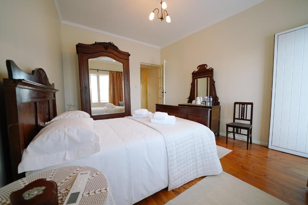 1 dormitorio con 1 cama blanca grande y espejo en Alijo Vintage House en Alijó