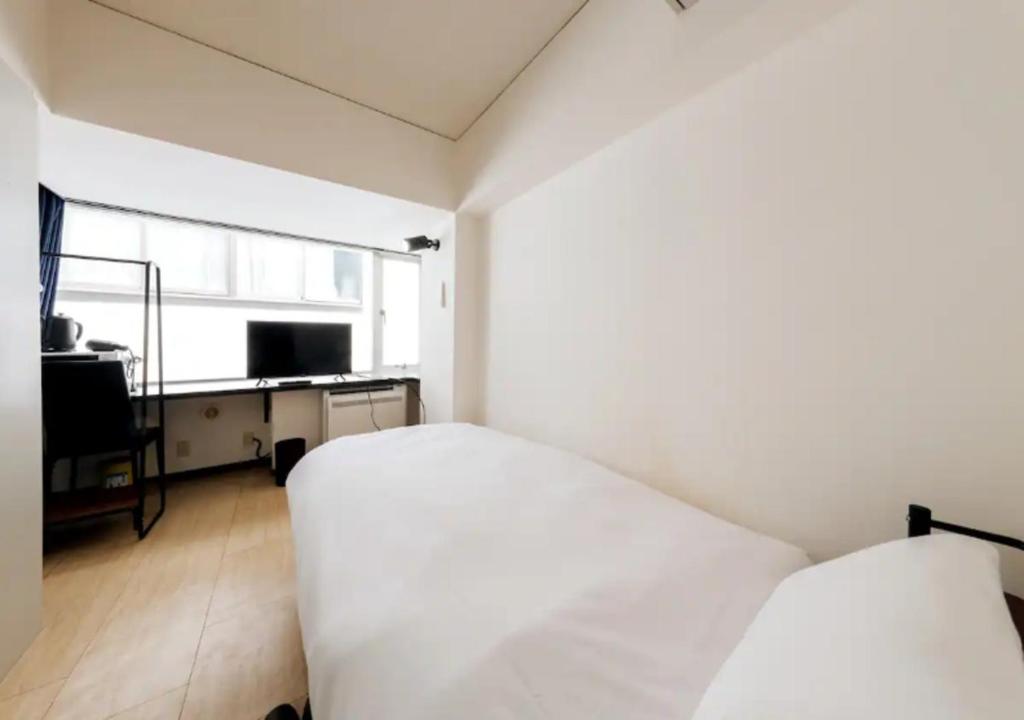 a bedroom with two beds and a desk and a window at ＰＩＡＺＺＡーＵ - Vacation STAY 78015v in Tokyo