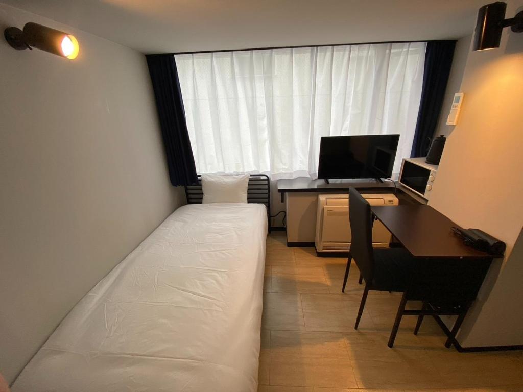 1 dormitorio con 1 cama y escritorio con ordenador en ＰＩＡＺＺＡーＵ - Vacation STAY 78021v, en Tokio