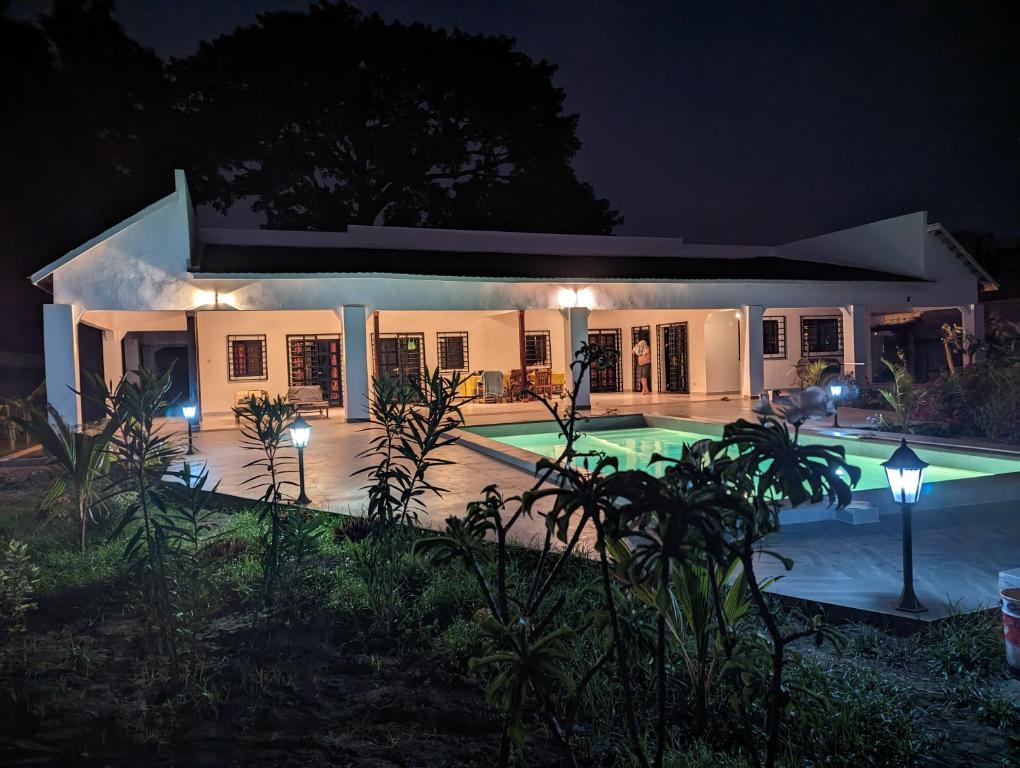 a villa with a swimming pool at night at Casa Lamar in Sanyang