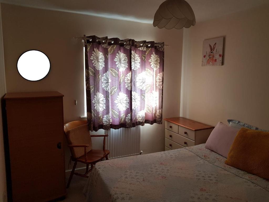 Double Bedroom in Crewe With Shared Kitchen and Bath في كرو: غرفة نوم بسرير ونافذة وكرسي