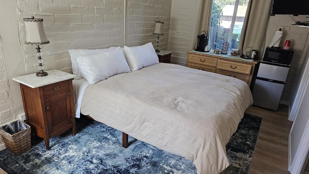 um quarto com uma cama, uma mesa e um frigorífico em Little European Lodge em Carmel Valley