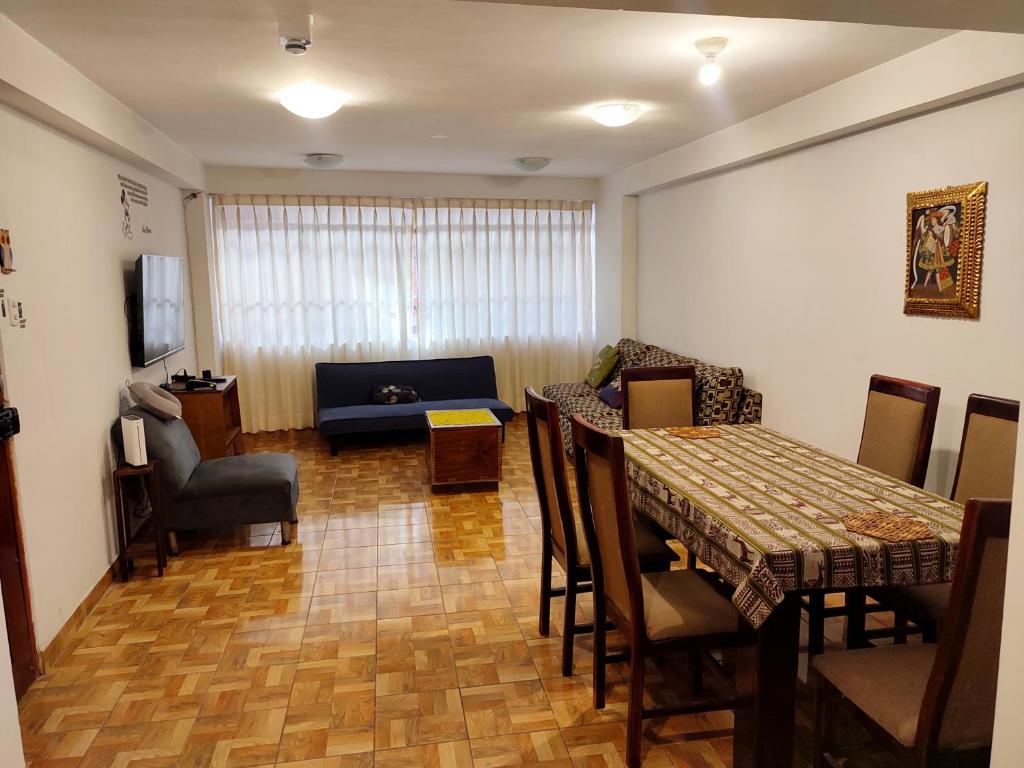 una sala de estar con una mesa y un sofá en Antarki Apartment, en Cusco