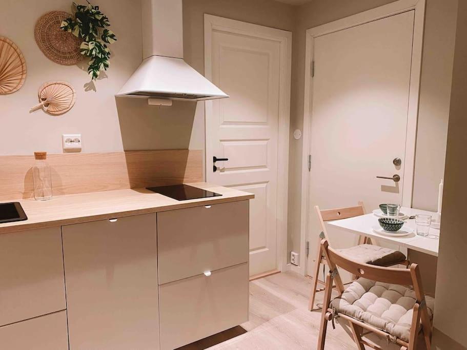 a kitchen with a counter and a table and chairs at Cute little appartment in Kristiansand
