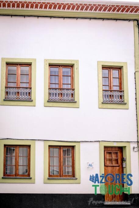a white building with windows and a sign on it at Atlântida Dream T1 in Angra do Heroísmo