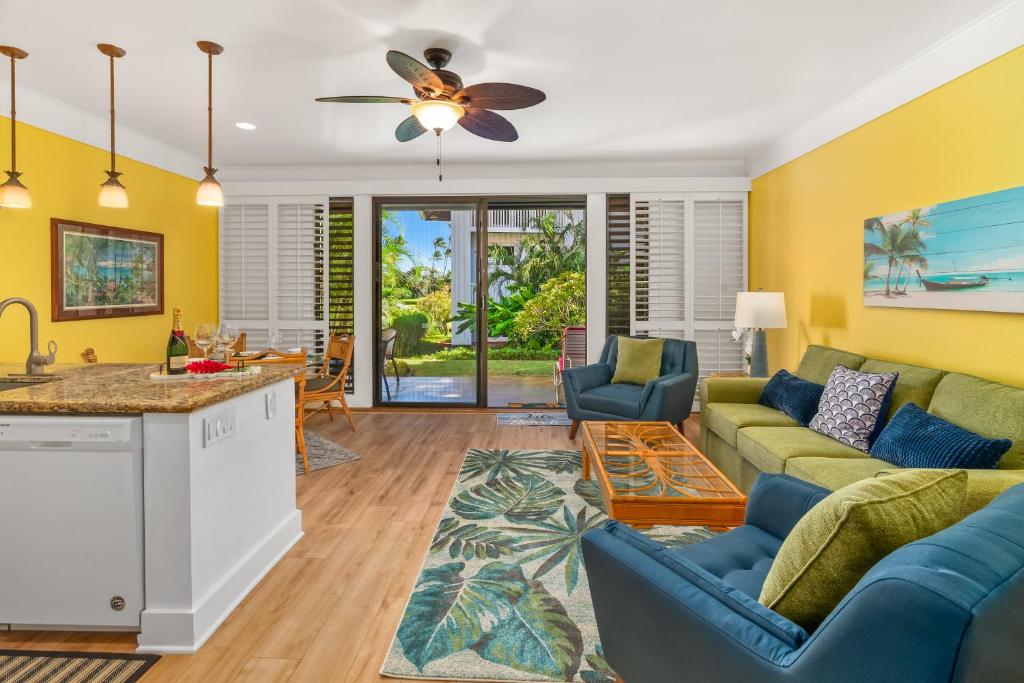 a living room with yellow walls and blue furniture at Kiahuna Paradise at Poipu beach, newly remodeled in Koloa