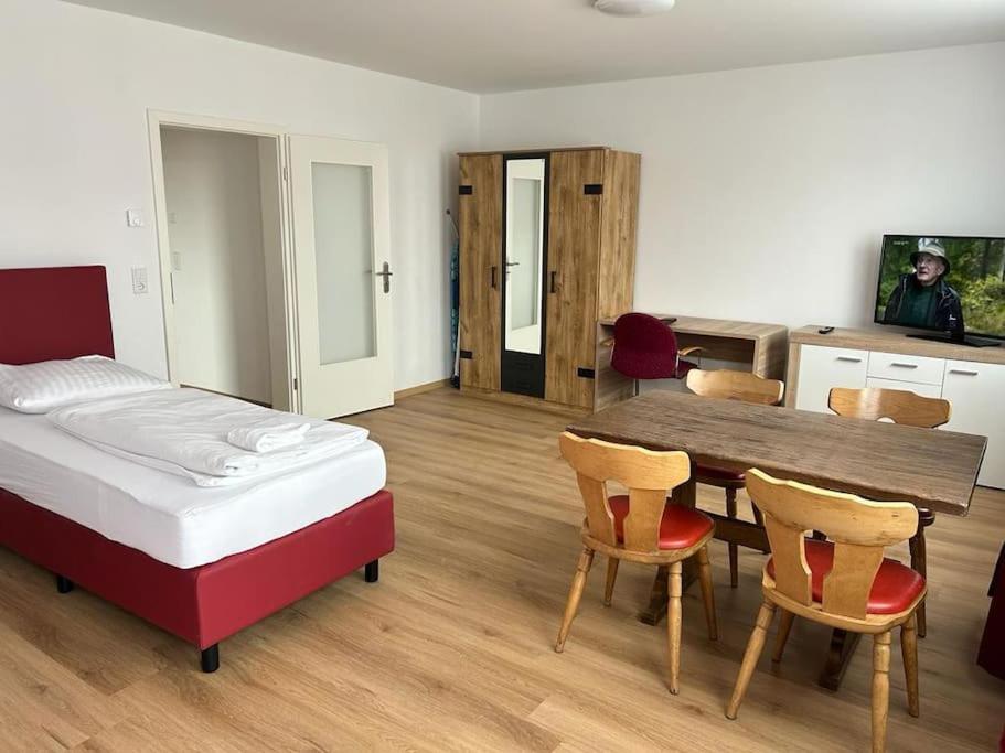 1 dormitorio con 1 cama, mesa y sillas en Othman Appartements Alte Schmiede 22 en Hannover