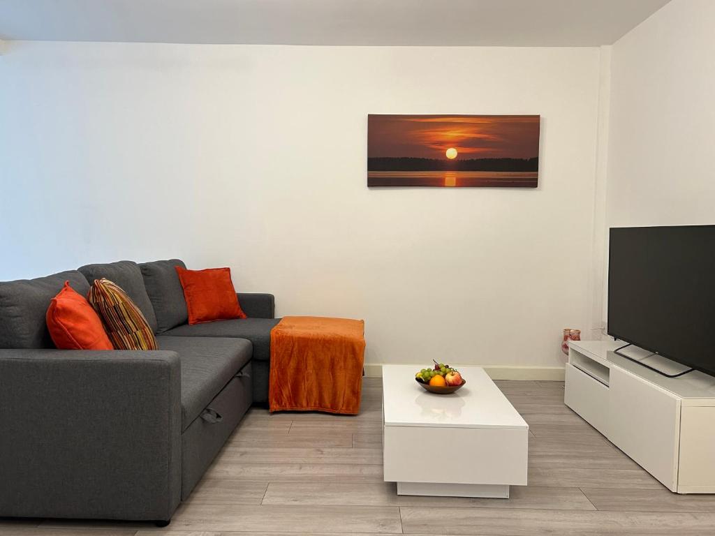 a living room with a couch and a tv at Modern 3 Bedroom House, Free Parking in Oxford in Oxford