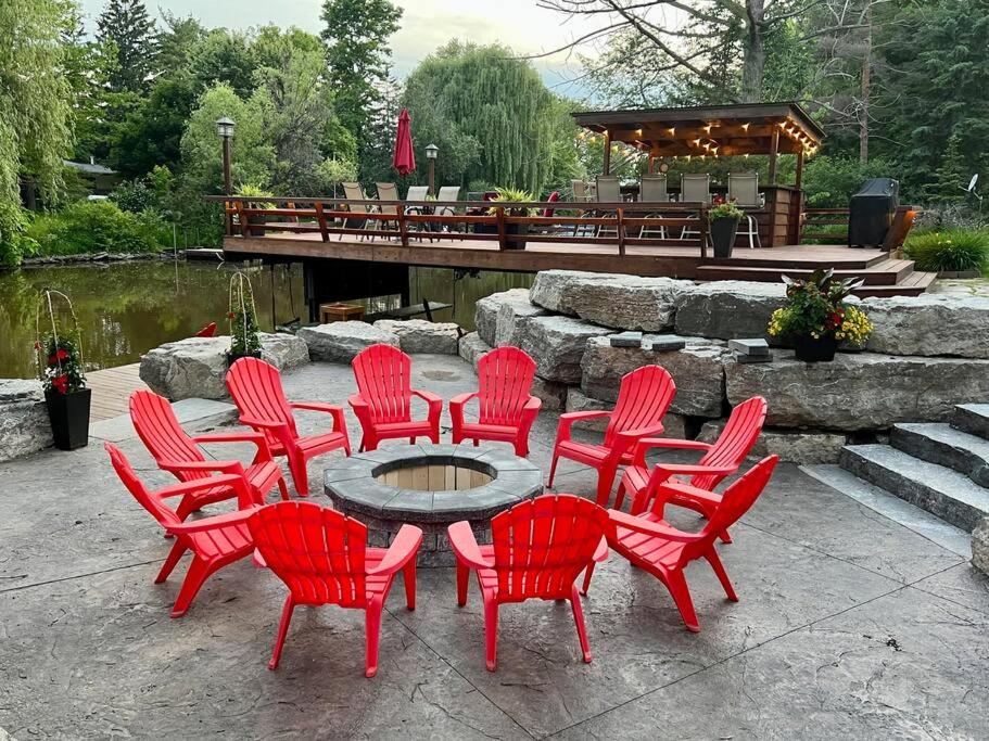 een groep rode stoelen rond een tafel bij Fabulous Rustic Waterfront Cottage in Niagara in Fort Erie