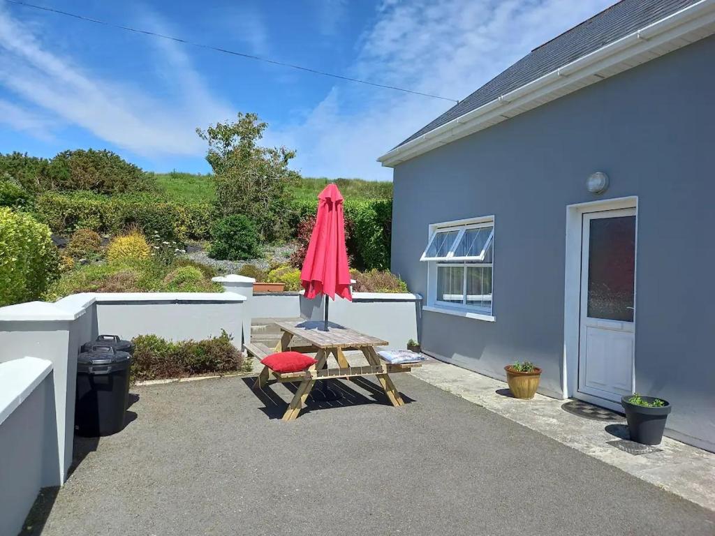 a patio with a picnic table and an umbrella at Anne's Cottage in Bantry